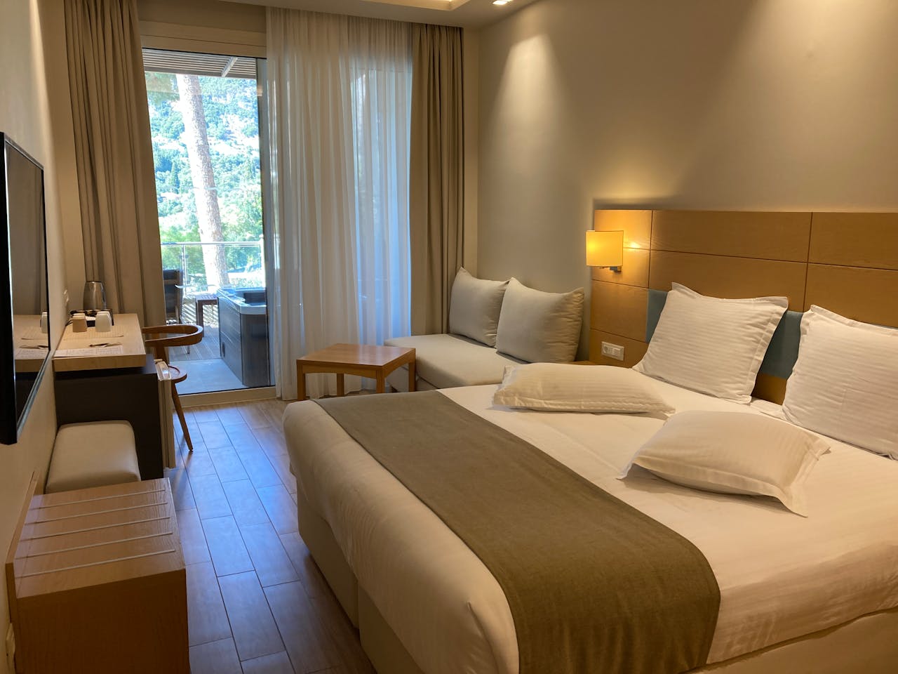Modern hotel room interior in Corfu featuring a cozy balcony view.